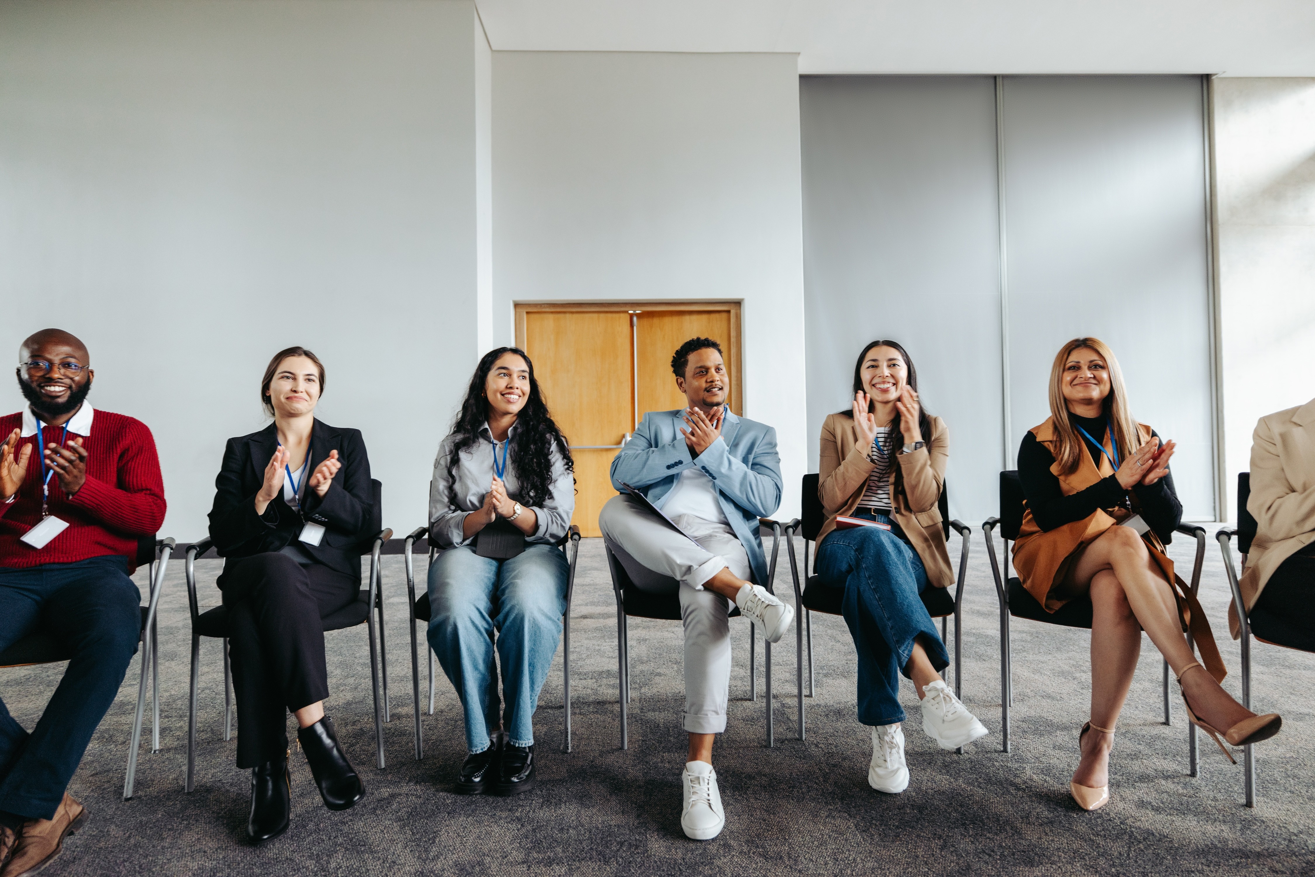 Shared enthusiasm: Diverse professionals applauding at a corporate workshop.