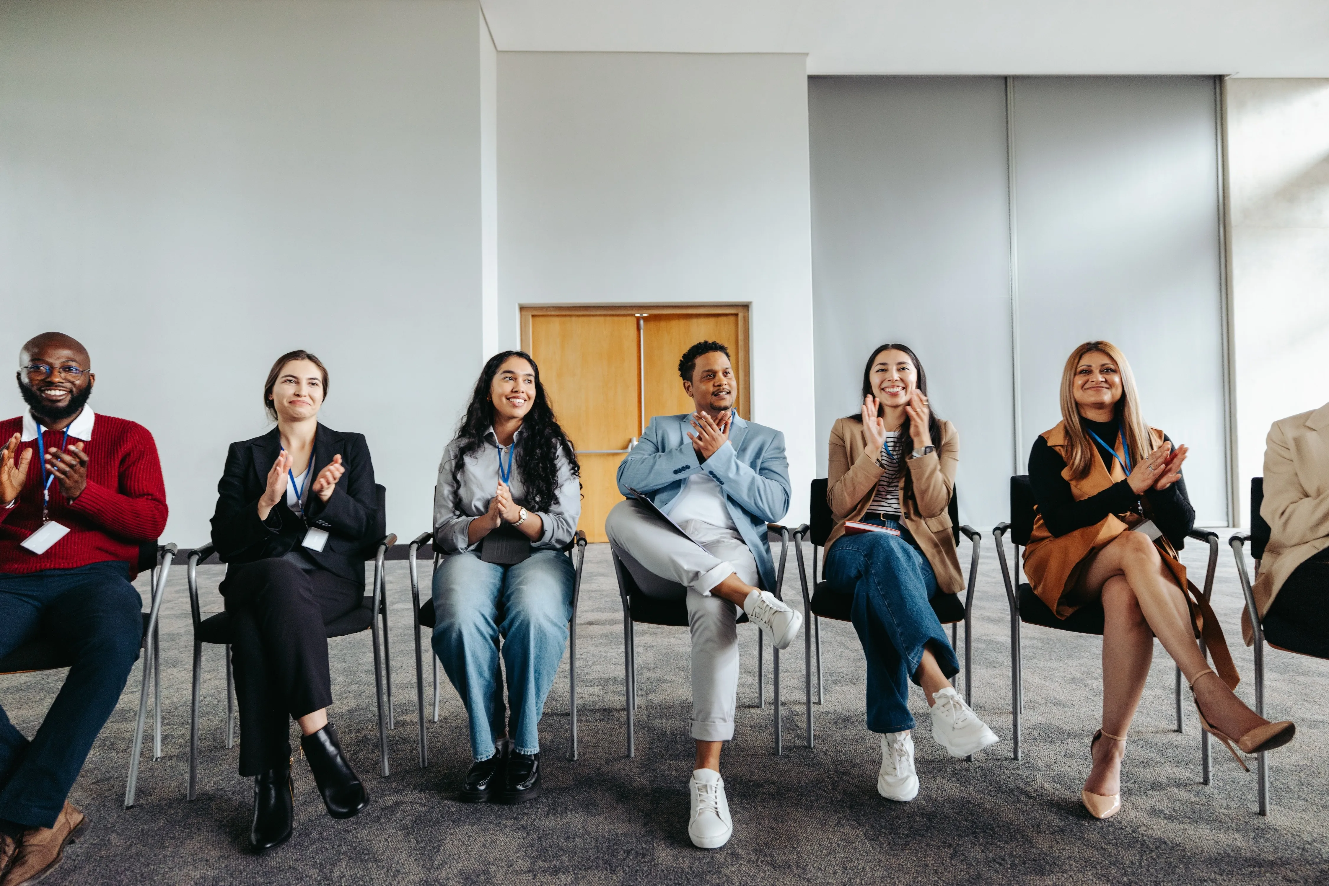 Shared enthusiasm: Diverse professionals applauding at a corporate workshop.